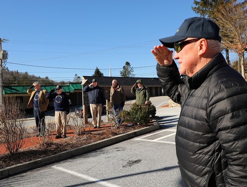 Saluting during the playing of Taps